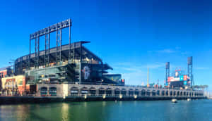 A Breathtaking View Of A Baseball Stadium Under Vibrant Evening Lights Wallpaper