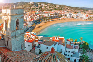 A Breathtaking View Of A Pristine Spanish Beach During Sunset Wallpaper