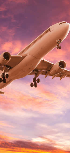 A Bright Pink Plane Soars Against A Blue Sky. Wallpaper