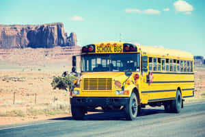 A Bright Yellow School Bus Parked Near The Park Wallpaper