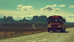 A Bright Yellow School Bus Parked Outdoors On A Sunny Day Wallpaper