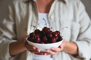 A Bunch Of Fresh Red Cherries On A Wooden Surface Wallpaper