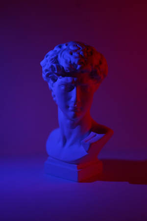 A Bust Of David With Blue And Red Lights Wallpaper