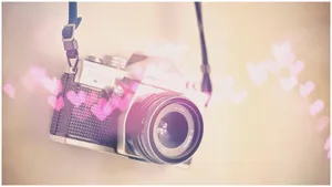 A Camera With Hearts Hanging From It Wallpaper