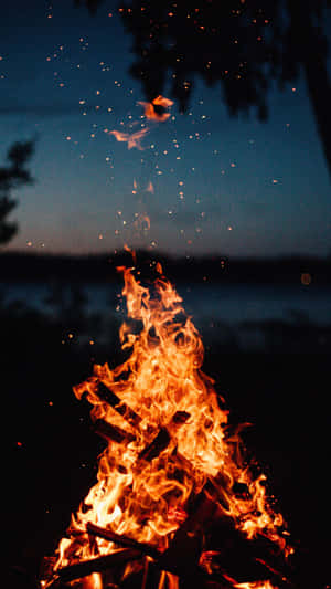 A Campfire With Flames In The Night Sky Wallpaper