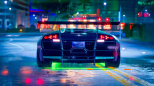 A Car Driving Down A Street At Night Wallpaper