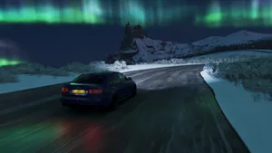 A Car Driving On A Snowy Road With The Aurora Lights On Wallpaper