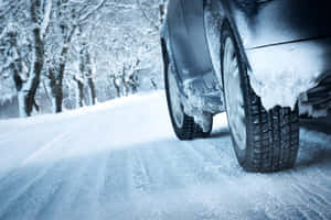 A Car Driving Through Snowy Winter Landscape Wallpaper