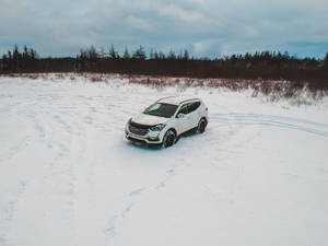 A Car Driving Through The Snow-covered Road Wallpaper