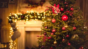A Christmas Tree With Decorations In Front Of A Fireplace Wallpaper