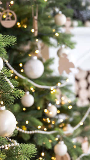 A Christmas Tree With Ornaments And A Fireplace Wallpaper