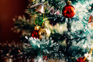 A Christmas Tree With Ornaments Hanging On It Wallpaper