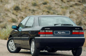 A Citroen Xantia Parked On The Side Of The Road At Sunset. Wallpaper