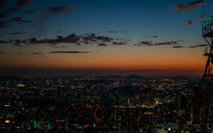 A City At Dusk With A Tower Wallpaper