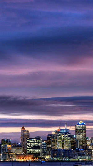 A City Skyline With A Boat In The Water Wallpaper