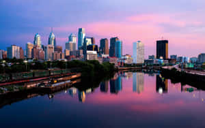 A City Skyline With A River In The Background Wallpaper