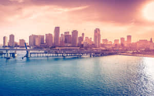 A City Skyline With Water And A Bridge Wallpaper