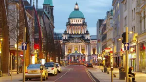 A City Street With A Building And Cars Wallpaper