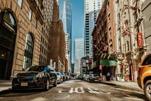 A City Street With Cars Parked In It Wallpaper