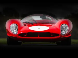 A Classic Yellow Ferrari Glistening In The Summer Sun Wallpaper