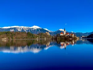 A Clear View Of The Julian Alps At Lake Bleds' Hillside Wallpaper