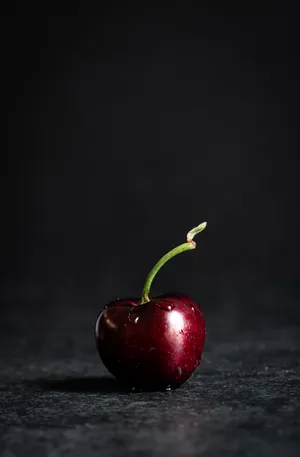 A Close-up Of A Fresh Black Cherry. Wallpaper