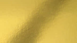 A Close Up Of A Metallic Gold Surface Wallpaper