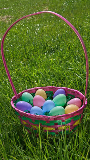 A Colorful Easter Basket Filled With Candy And Eggs Wallpaper