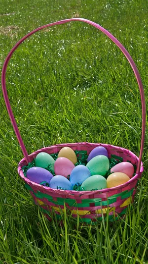 A Colorful Easter Basket Filled With Candy And Eggs Wallpaper