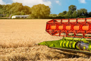 A Combine Harvester Is In The Field Wallpaper