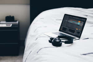 A Comfortable Pair Of Headphones And A Laptop Greatly Enhances Listening And Computing Experience. Wallpaper