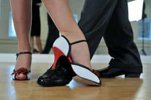 A Couple Of People In Black And White Shoes Standing In A Dance Studio Wallpaper