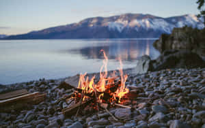 A Cozy Beach Campfire At Sunset Wallpaper