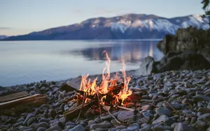 A Cozy Beach Campfire At Sunset Wallpaper
