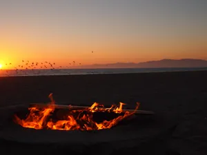 A Cozy Beach Campfire At Sunset Wallpaper