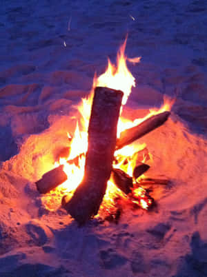 A Cozy Beach Campfire Under A Starry Night Sky Wallpaper