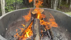 A Cozy Fall Bonfire Surrounded By Vibrant Autumn Foliage. Wallpaper