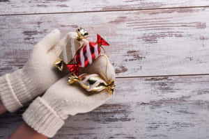 A Cozy Pair Of Knitted Mittens On A Wooden Surface Wallpaper