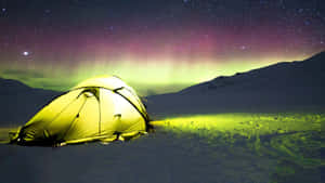 A Cozy Winter Camping Setup In A Snowy Forest Landscape Wallpaper