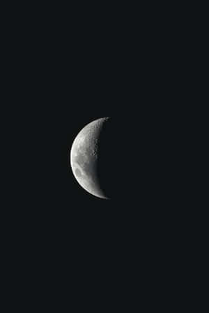 A Crescent Is Seen In The Dark Sky Wallpaper