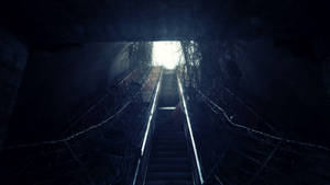 A Dark Stairway With A Light Shining Through Wallpaper