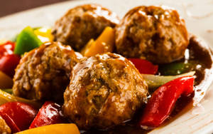 A Delectable Close-up Of Meat Balls In Tomato Sauce With Bell Pepper Wallpaper