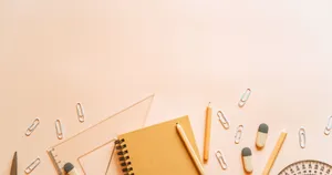 A Desk With Pens, Pencils, A Notebook And A Pencil Case Wallpaper