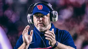 A Determined Football Coach Strategizing On The Sideline Wallpaper