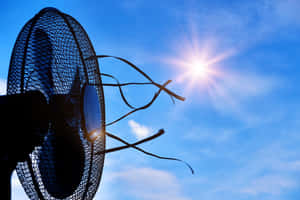 A Fan Is Shown Against A Blue Sky Wallpaper