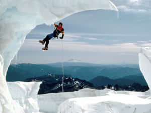 A Fearless Ice Climber Conquering A Challenging Frozen Waterfall Wallpaper