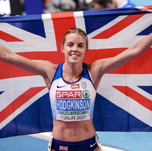 A Female Athlete Holding Up An British Flag Wallpaper
