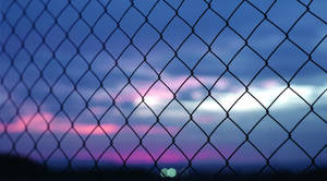 A Fence With A View Of The Sky Wallpaper