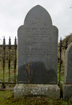 A Foggy Cemetery Scene With An Eerie Gravestone Wallpaper