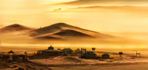 A Foggy Scene With A Village In The Distance Wallpaper